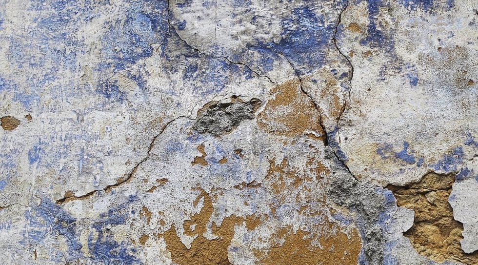 Crepe su un muro scrostato, in evidente stato di danneggiamento