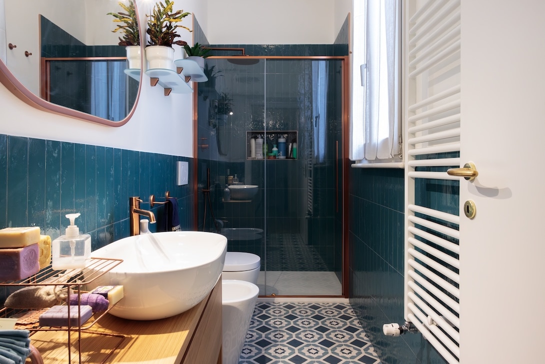 Ristrutturazione bagno moderno con piastrelle verde scuro e doccia walk in realizzata da Creo Casa Milano